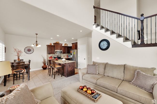 Living room with light tile patterned flooring, a chandelier, and recessed lighting | Image 5