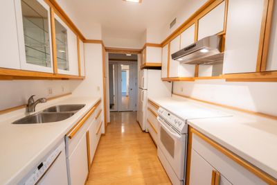 Galley kitchen with lots of cabinet space for storage. Walk thru to formal dining room. Kitchen is well lit and easy to cook a full meal in. | Image 2