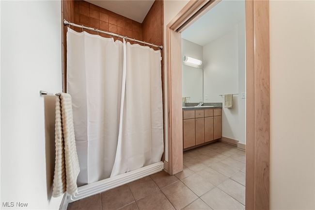 Full bathroom featuring tile floors, vanity, and a walk-in shower. | Image 26