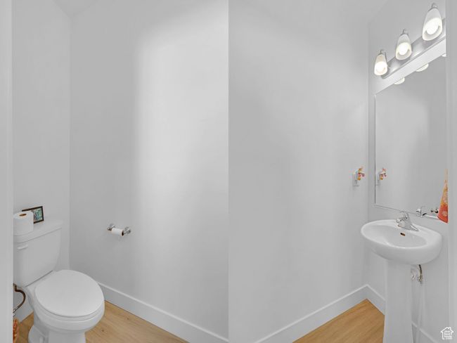Half bathroom with wood finished floors, baseboards, and toilet | Image 9