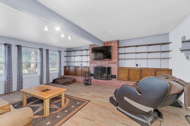 Living room featuring light wood-style flooring and a brick fireplace | Image 14