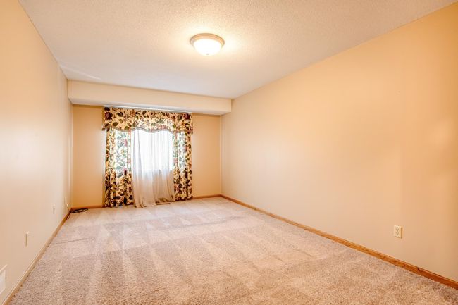 Spacious primary bedroom with plush carpet, soft natural light, and a neutral palette—ideal for any personal style. | Image 16