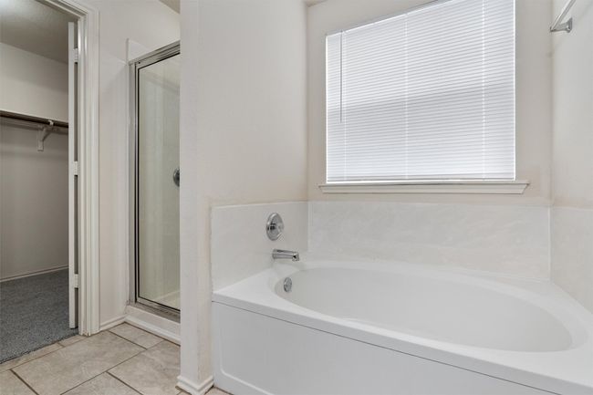 Bathroom featuring a bath, a stall shower, a walk in closet, and tile patterned flooring | Image 13