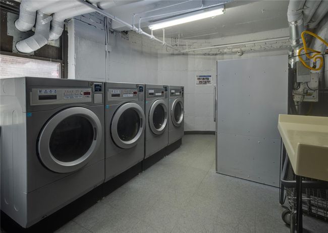Communal laundry room featuring washer and dryer and tile patterned floors | Image 19