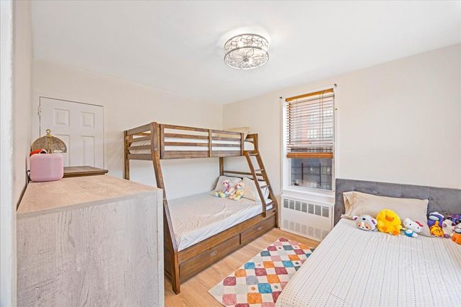 Bedroom with radiator and light wood finished floors | Image 13