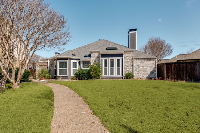 Front view of house with roof with shingles, brick siding, a chimney, a lawn, and fence | Image 29