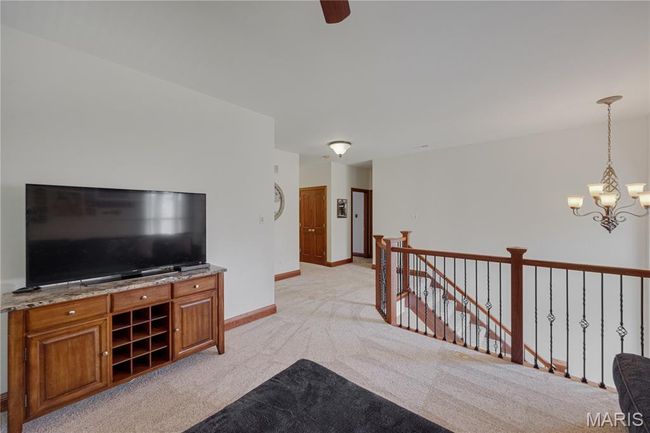 Living area featuring a chandelier, light colored carpet, and ceiling fan | Image 30