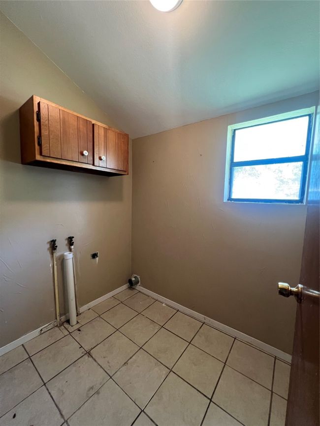 Laundry area with cabinet space, light tile patterned flooring, and hookup for a washing machine | Image 17