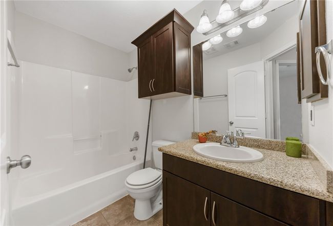 Bathroom featuring vanity, toilet, washtub / shower combination, and tile patterned floors | Image 14
