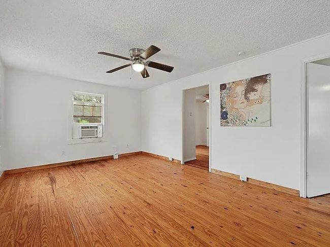 Unfurnished room featuring a textured ceiling, ceiling fan, and light wood-type flooring | Image 8