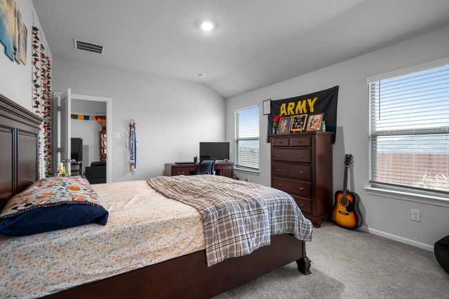 Bedroom featuring light colored carpet, visible vents, lofted ceiling, and baseboards | Image 14