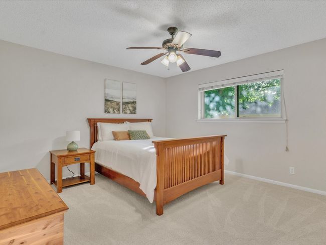 Bedroom with carpet floors, a textured ceiling, baseboards, and a ceiling fan | Image 30