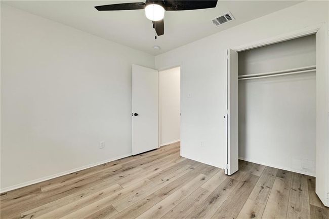 Unfurnished bedroom featuring wood finished floors, a closet, and a ceiling fan | Image 7