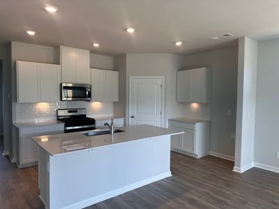 WHITE CABINETRY, SUBWAY TILE BACKSPLASH, QUARTZ COUNTERTOPS, PANTRY, GAS RANGE, TANKLESS GAS WATER HEATER | Image 2