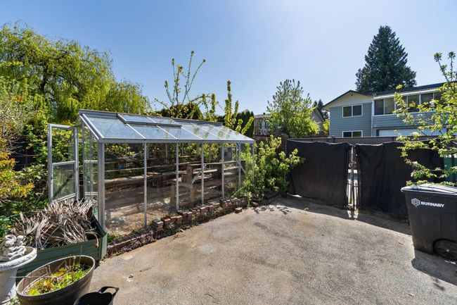View of patio / terrace with fence, a greenhouse, and an outbuilding | Image 38