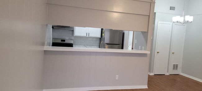 Kitchen featuring freestanding refrigerator, range, wood finished floors, decorative backsplash, and extractor fan | Image 16