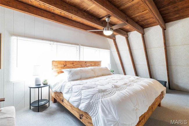 Bedroom with beamed ceiling, wood ceiling, a ceiling fan, and carpet floors | Image 26