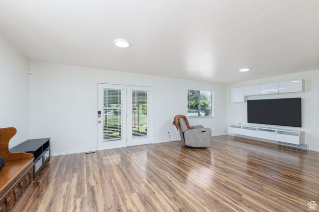 Living area with wood finished floors, baseboards, and recessed lighting | Image 8