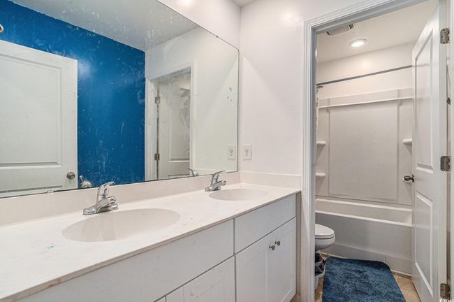 Full bathroom featuring toilet, double vanity, and bathing tub / shower combination | Image 19