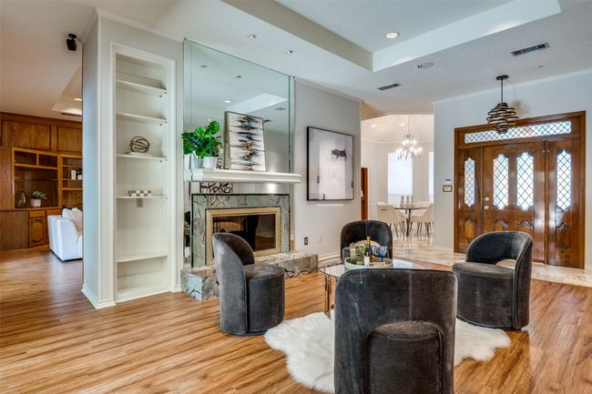 Living area with built in shelves, ornamental molding, light wood-type flooring, recessed lighting, and a tray ceiling | Image 13
