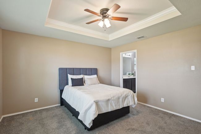 Bedroom with visible vents, crown molding, carpet floors, and a raised ceiling | Image 22