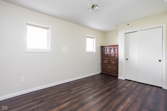 unfurnished bedroom featuring dark wood finished floors and a closet | Image 20