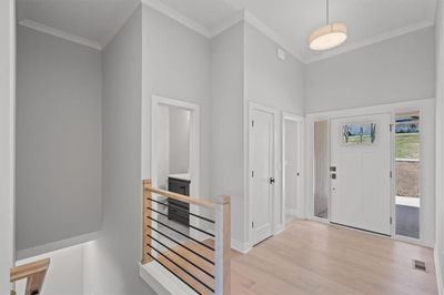 Foyer entrance featuring light hardwood / wood-style floors, a high ceiling, and crown molding | Image 3