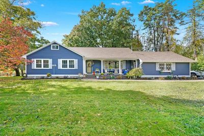 Ranch-style house with covered porch and a front yard | Image 1