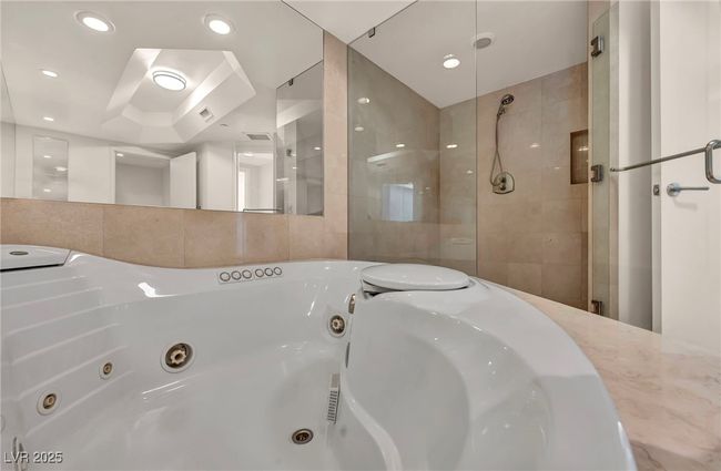 Bathroom featuring a shower stall, tile walls, and a whirlpool tub | Image 41