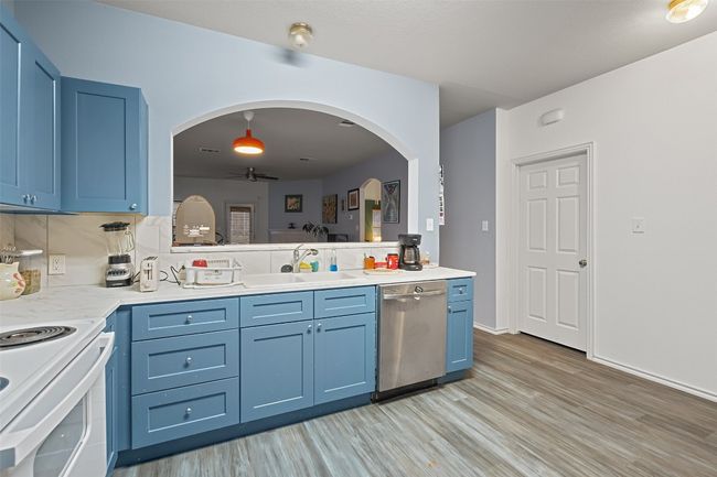 The heart of the home is a beautiful kitchen with wrap around counters, custom cabinet color, electric stove, microwave, and recent refrigerator with is included. Recent upgrades include vinyl plank flooring, water heater, range, roof and HVAC. | Image 12