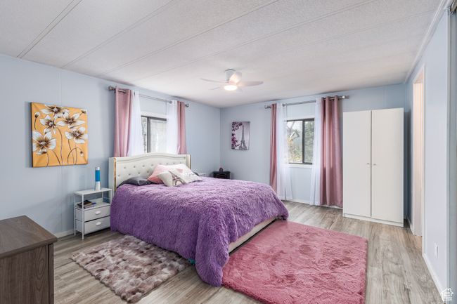 Bedroom featuring light wood finished floors, baseboards, and ceiling fan | Image 10