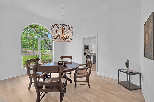 Dining space featuring light wood-type flooring, plenty of natural light, and a chandelier | Image 18