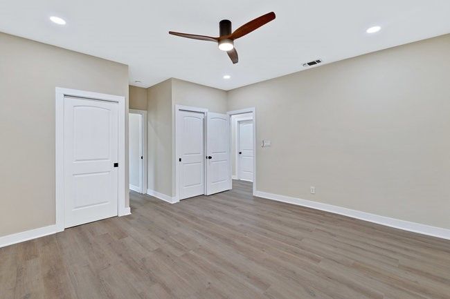 Unfurnished bedroom featuring wood finished floors, recessed lighting, visible vents, and baseboards | Image 14