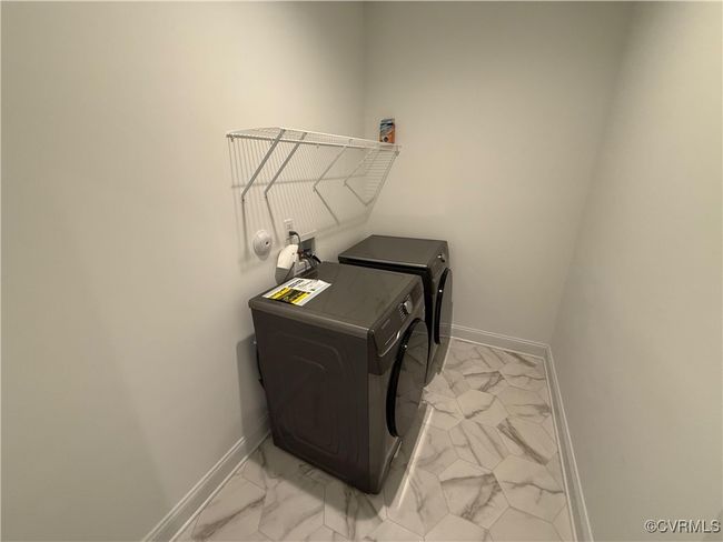 Laundry room featuring light marble finish flooring, baseboards, washing machine and dryer, and pet washing area | Image 8