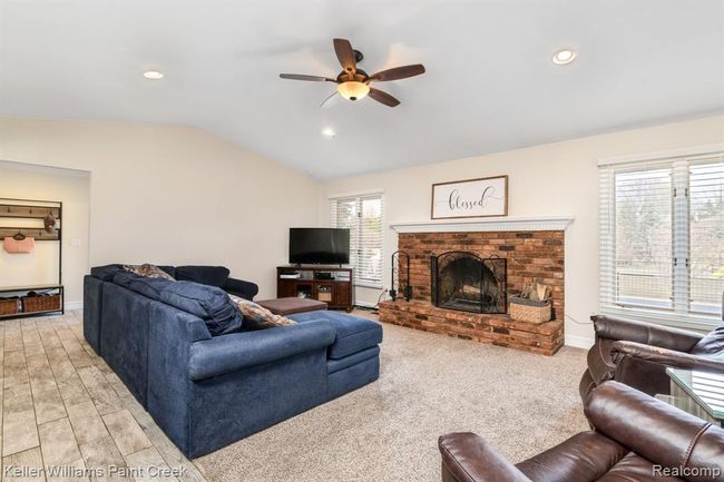 Spacious great room overlooks the grounds and features vaulted ceilings & a lovely brick fireplace! | Image 1