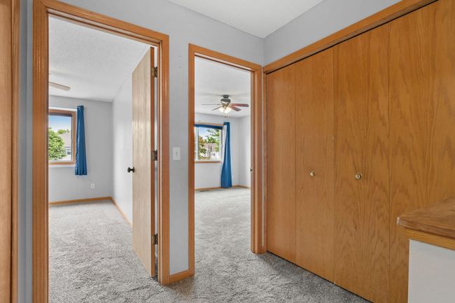 Hallway leading to both bedrooms, with large closets providing extra storage. | Image 16