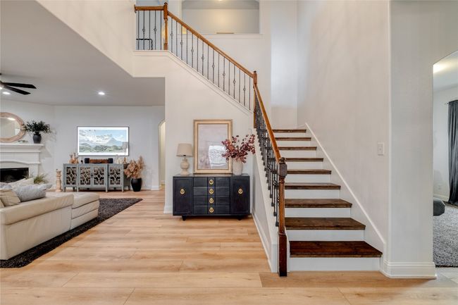 Staircase with arched walkways, wood finished floors, a high ceiling, recessed lighting, and a ceiling fan | Image 9