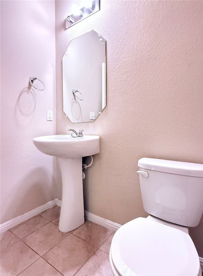 Half bath featuring a textured wall and tile patterned floors | Image 11