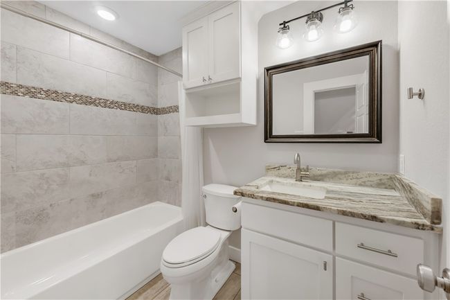 Bathroom with vanity, toilet, shower / tub combination, wood finished floors, and baseboards | Image 17