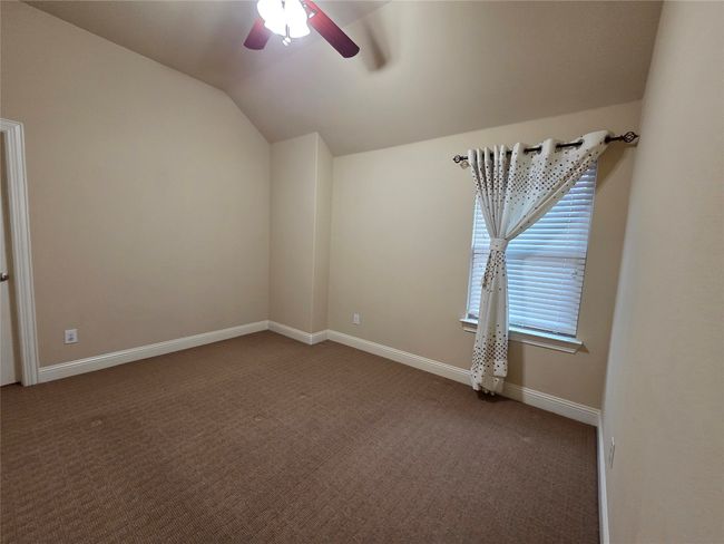 Carpeted spare room with lofted ceiling and a ceiling fan | Image 30