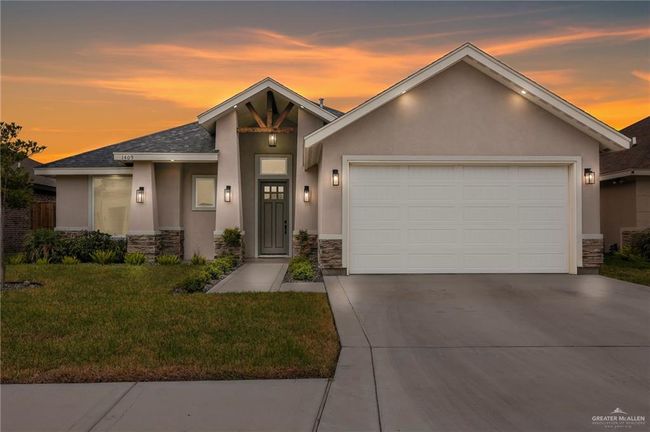 Mid-century modern home featuring a garage, driveway, stone siding, and stucco siding | Image 4