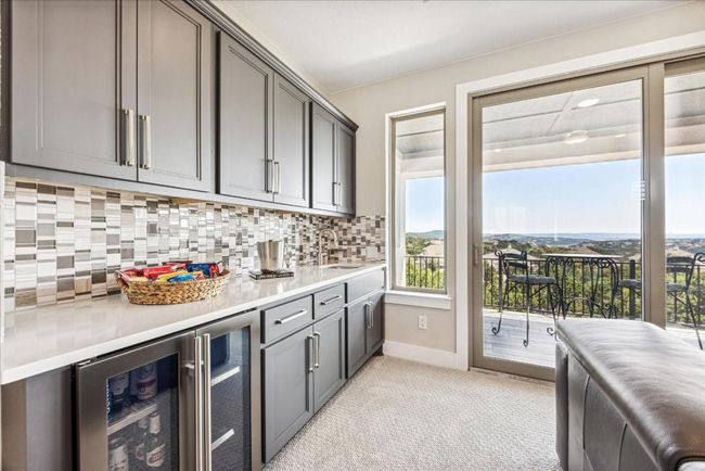 A convenient wet bar with a beverage fridge ensures refreshments are always on hand for guests upstairs. 16 x8 sliding doors open to the upper balcony, seamlessly extending the entertaining space. | Image 24
