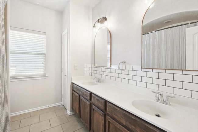 Bathroom with double vanity, tile patterned flooring, and backsplash | Image 21