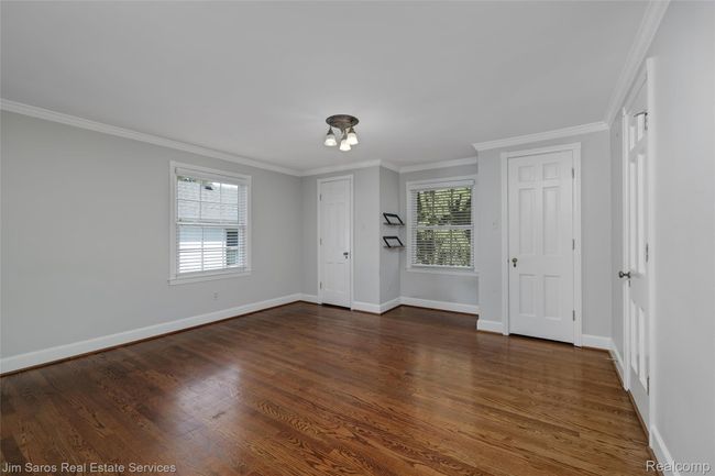 Empty room featuring healthy amount of natural light, crown molding, and dark wood-style floors | Image 22
