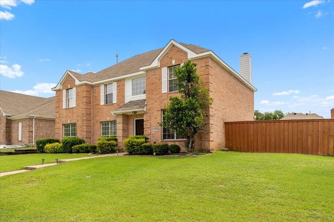 View of front of property featuring brick siding, a chimney, and roof with shingles | Image 4