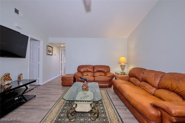 Living room with light wood-type flooring and vaulted ceiling | Image 9