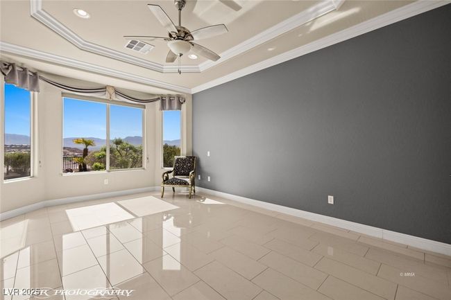 Unfurnished room featuring visible vents, baseboards, ornamental molding, ceiling fan, and a tray ceiling | Image 40
