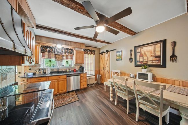 Kitchen featuring stainless steel dishwasher, a barn door, a sink, beamed ceiling, and range with electric cooktop | Image 9