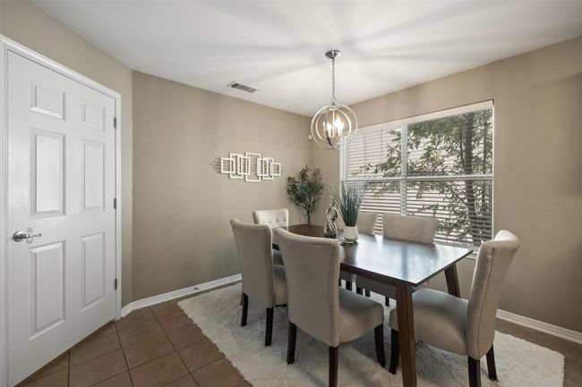 Dining space featuring a chandelier, tile patterned floors, and baseboards | Image 10