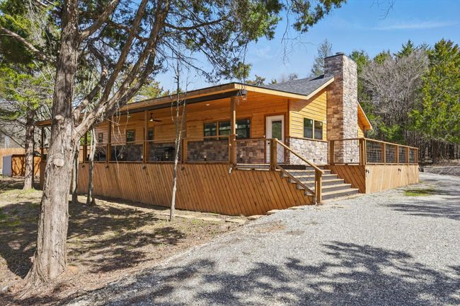 View of front of house with stone siding, a chimney, and gravel driveway | Image 35